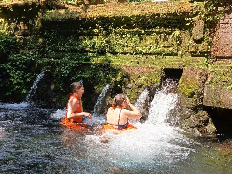 Voyageurs se baignant au pied d’une cascade dans un temple d’eau